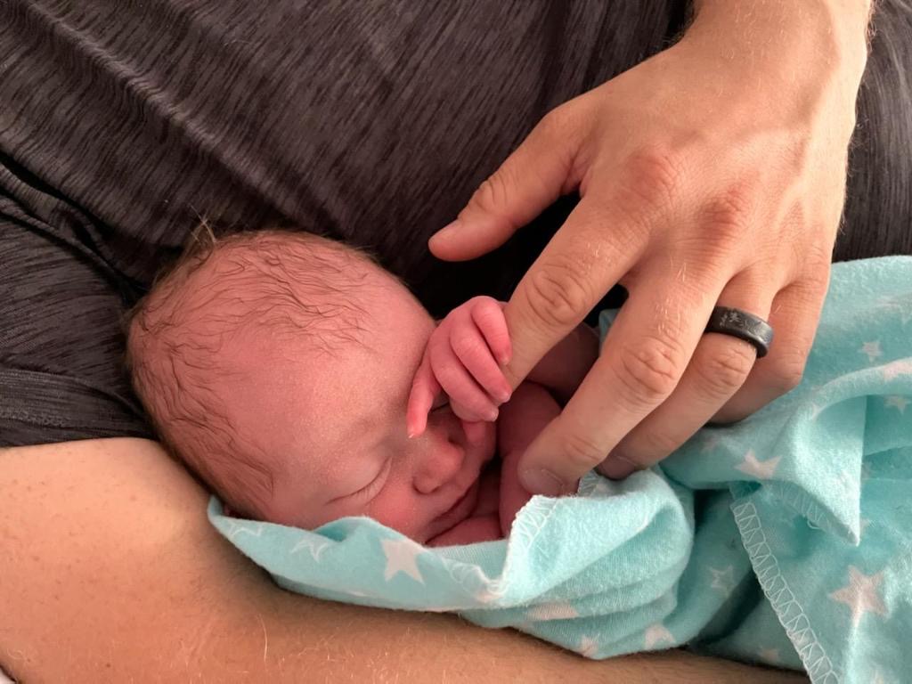 Lizzy holding her daddy's hand following the home birth