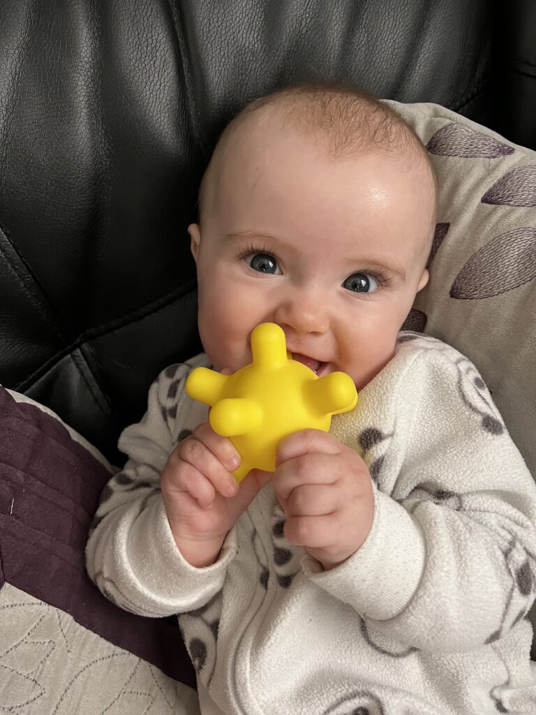 Lizzy teething on a toy